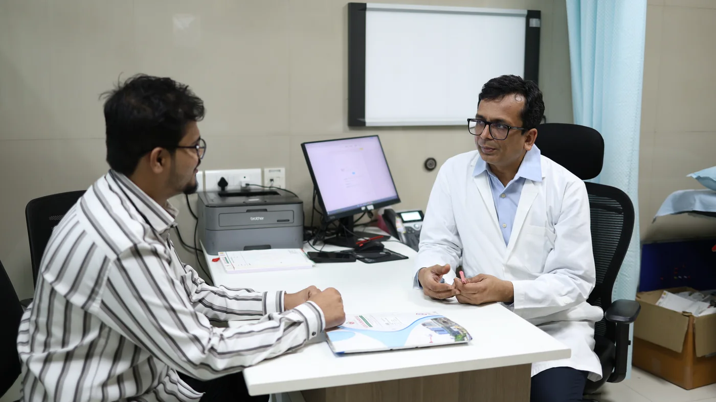 Dr. Arvind Patel in consultation with a patient at Kiran Hospital, Surat