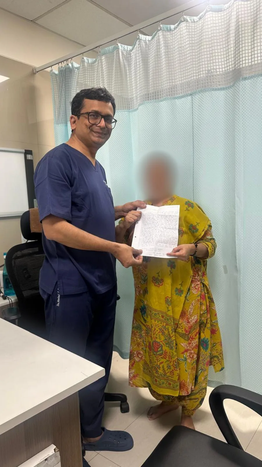 A hand transplant patient presenting a hand-written thank-you letter to Dr. Arvind Patel